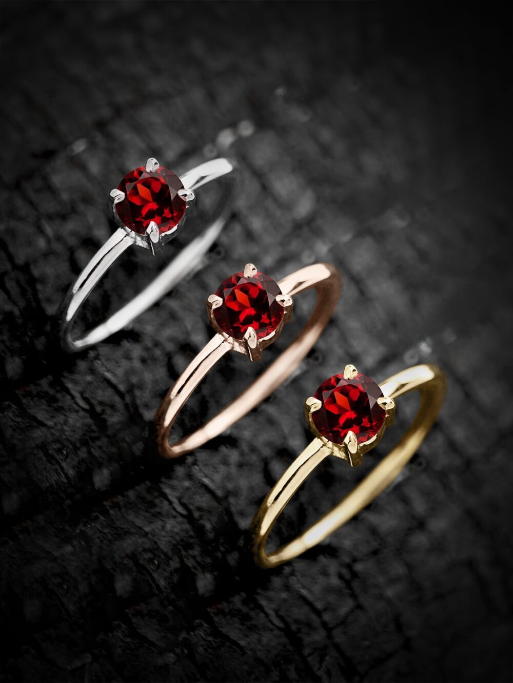 Classic round garnet ring in sterling silver with white rhodium finish on a textured background