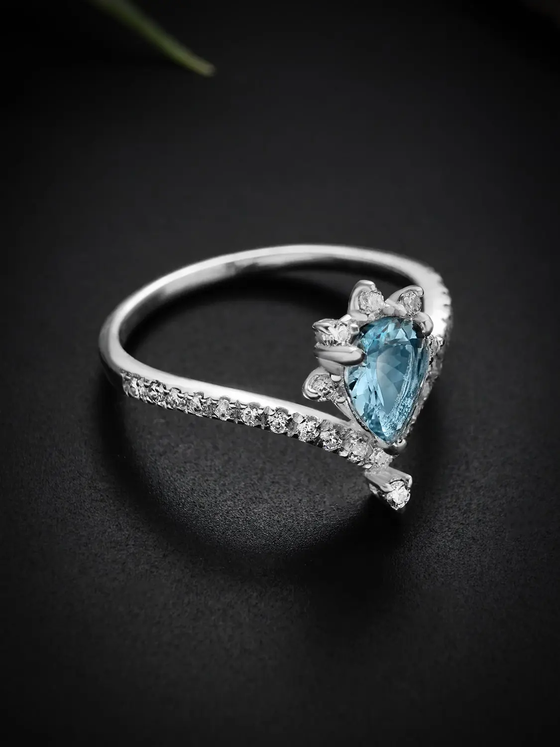 Stellar glow blue topaz ring showcased against a dark background